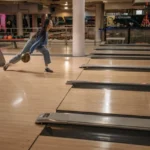 Keilahallissa keilapalloa heittävä henkilö esittelemässä yhtä Suomen suosituimmat harrastukset.