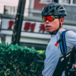 Kypärässä ja aurinkolaseissa oleva mies ajaa polkupyörällä ilmentäen saku koivu eroaan henkeä.