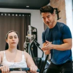 Mies ja nainen treenaavat yhdessä kuntosalilla keskittyen kuntotavoitteisiinsa, mukaan lukien soutulaite laihdutus.